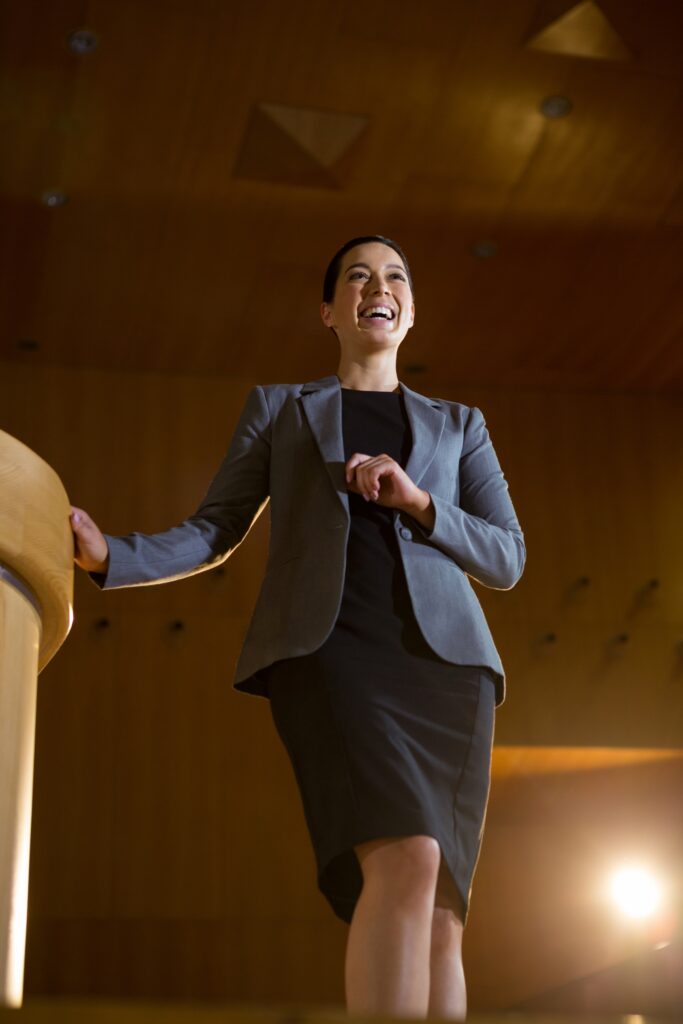 Confident woman delivers presentation on a stage | Social Anxiety Disorder Clinical Studies