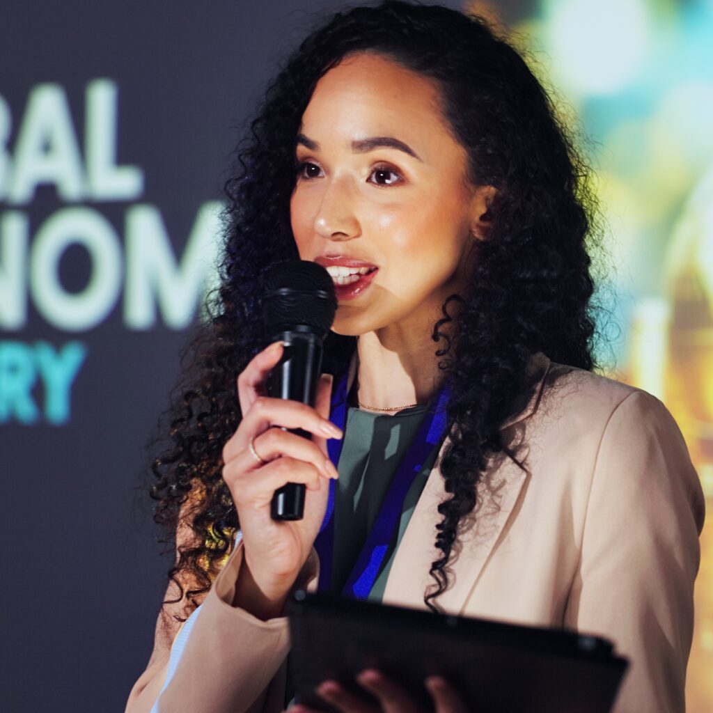 Young mixed-race woman speaks confidently at a conference due to her results from SAD clinical trials